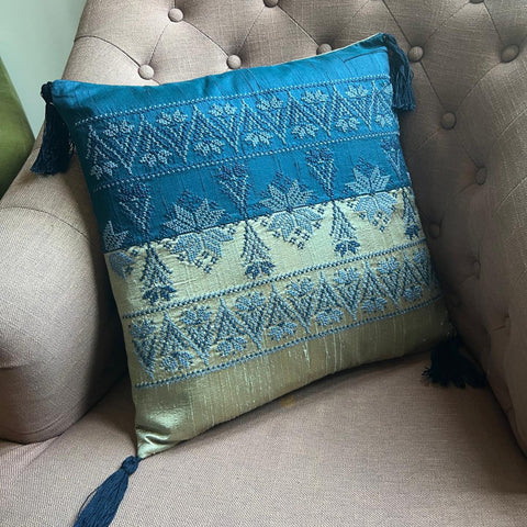Decorative pillow with blue and white patterns on a beige sofa